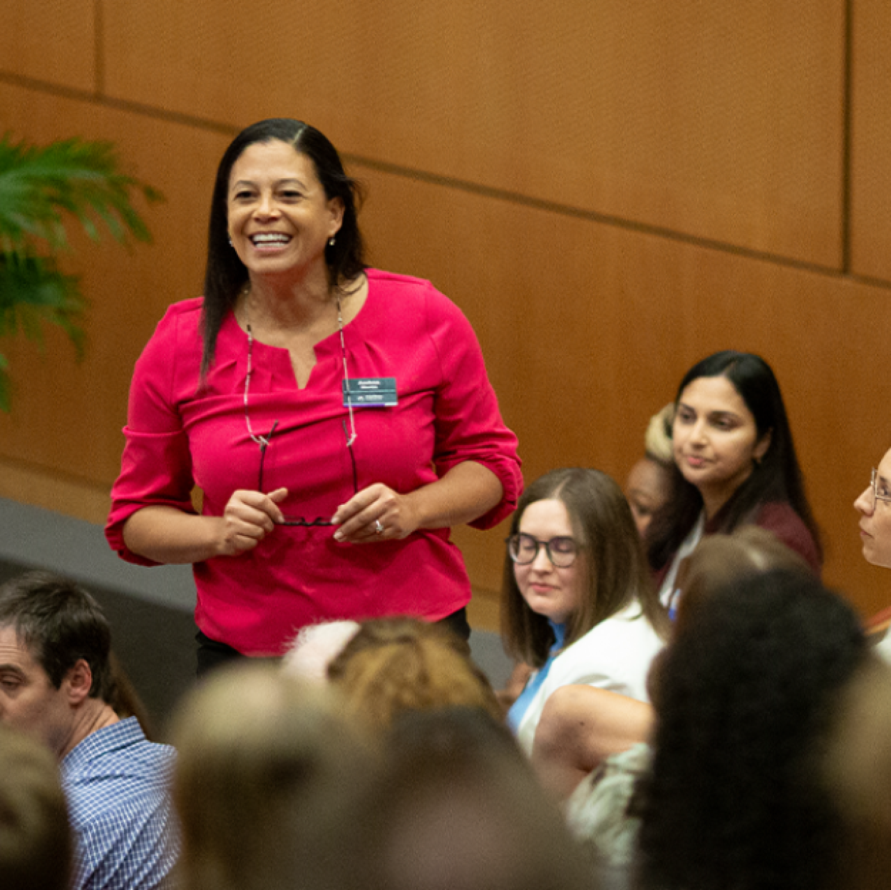 Law professor standing amid law students in a lecture room.